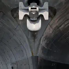 A close-up view of the bow of a large ship, showing the anchor and chain locker mechanism mounted on the hull.